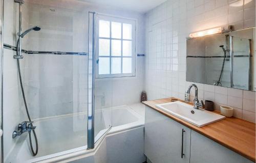 ein Bad mit einer Badewanne, einer Dusche und einem Waschbecken in der Unterkunft 3 Bedroom Nice Home In Clohars-carnoet in Keranquernat