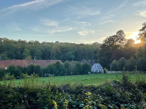 uma vista para um campo com um celeiro à distância em Ferienhaus am Wasserschloss Haus Marck em Tecklenburg