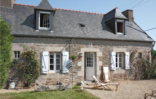 une ancienne maison en pierre avec un drapeau devant elle dans l'établissement Holiday Home Route De Pen Woas, à Pleumeur-Gautier