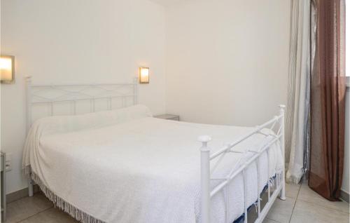 モリアニ・プラージュにあるStunning Apartment In Moriani Plage With Kitchenetteの白いベッドフレーム付きのベッドルームの白いベッド1台
