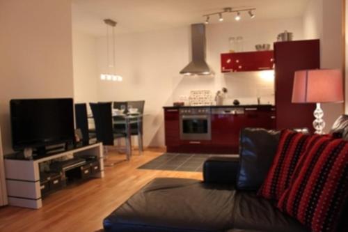 een woonkamer met een bank en een keuken bij Jana 4 by SMR Rauris Apartments - inc Spa and National Summercard - near Gondola in Rauris