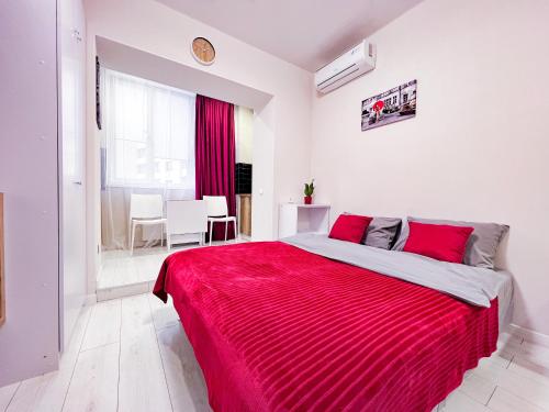 a bedroom with a large bed with a red blanket at Новая студия на Южном вокзале in Kharkiv