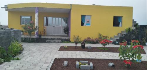 ein gelbes Haus mit einer Terrasse davor in der Unterkunft Ciza e Rose in Portela