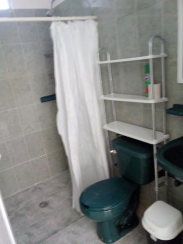 a bathroom with a green toilet and a shower at Hotel Azulejos in Chachalacas