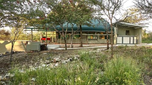 una casa que se está construyendo con árboles delante de ella en ZuriCamp - Tent Madini, en Tsumeb