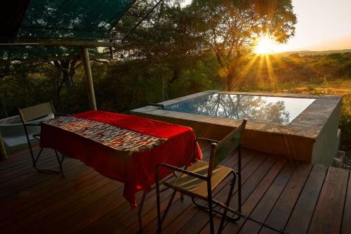 eine Terrasse mit einem Tisch und Stühlen sowie einem Pool in der Unterkunft ZuriCamp - Tent Madini in Tsumeb