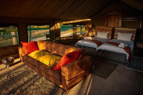 ein Wohnzimmer mit einem Sofa und einem Bett in der Unterkunft ZuriCamp - Tent Madini in Tsumeb