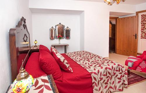 a bedroom with a red bed and a red couch at Lovely Apartment In Montefrio in Montefrío