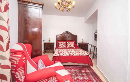 a bedroom with a red bed and a red chair at Lovely Apartment In Montefrio in Montefrío