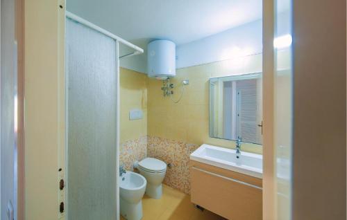 ein Badezimmer mit einem WC, einem Waschbecken und einem Spiegel in der Unterkunft Villa Rosalba in Olbia