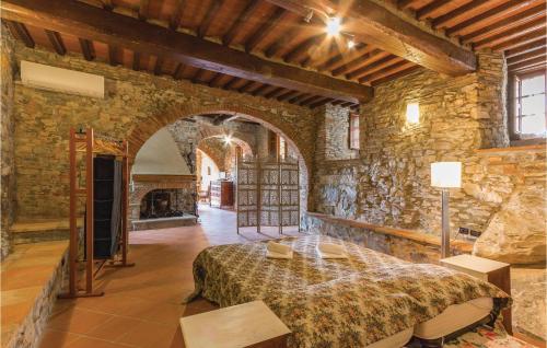 マッサローザにあるAwesome Home In Pieve A Elici -lu- With 4 Bedrooms And Wifiの石壁のベッドルーム1室(大型ベッド1台付)