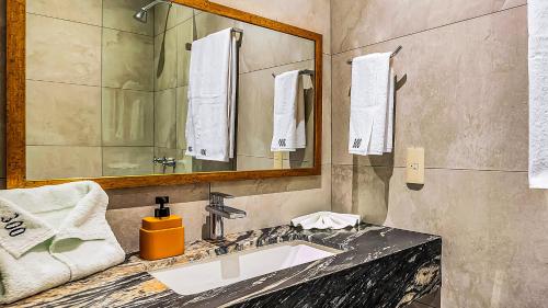 a bathroom with a sink and a mirror at Marboka Hotel & Suites in Puerto Vallarta