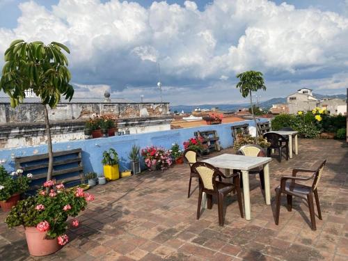 a patio with tables and chairs on a roof at Check Inn Bed and Breakfast in Cuenca