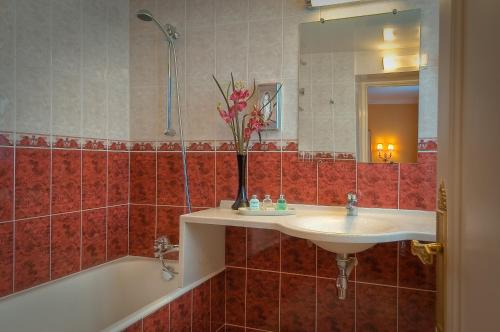 a bathroom with a sink and a bath tub at Hôtel de Varenne in Paris