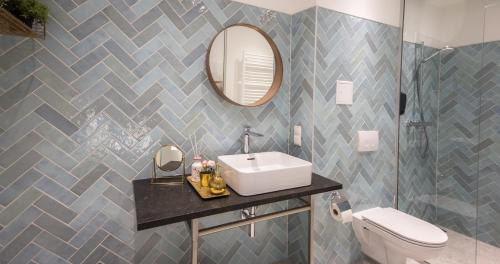 a bathroom with a sink and a mirror and a toilet at Nikolai Homes in Vienna