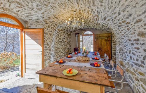 a long table in a room with a stone wall at 4 Bedroom Lovely Home In Cedegolo in Cedegolo