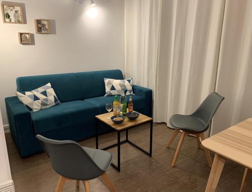 un salon avec un canapé bleu et une table dans l'établissement Sanary Bandol Piscine Plage Calme, à Sanary-sur-Mer