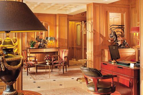 a living room with a table and chairs and a lamp at Hôtel de Varenne in Paris