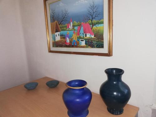 two blue vases sitting on a table under a painting at Villa Ceirano in Lagnasco