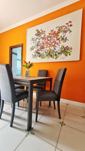 a dining room table with chairs and a painting on the wall at Il Gioiello del Circeo in San Felice Circeo