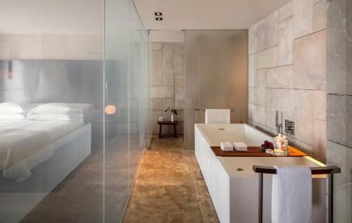 a bathroom with a bath tub, sink, and mirror at Mamilla Hotel in Jerusalem