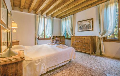 a bedroom with a bed and a dresser and windows at Estuario in Venice