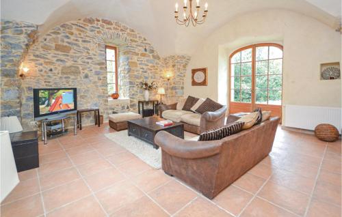un grand salon avec un mur en pierre dans l'établissement 5 Bedroom Pet Friendly Home In Anduze, à Anduze