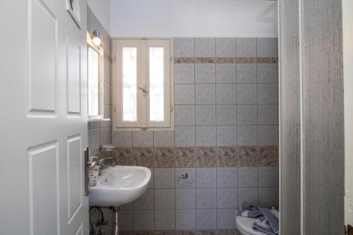 uma casa de banho com um lavatório e um WC. em Akrothalassia em Adamas