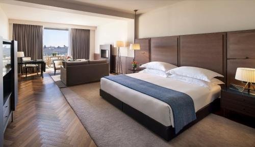 a bedroom with a large bed and a living room at The David Citadel Jerusalem in Jerusalem
