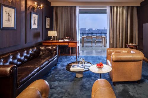 a living room with a leather couch and a table at The David Citadel Jerusalem in Jerusalem