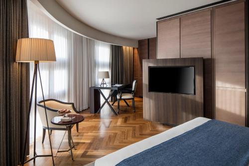 a hotel room with a bed and a flat screen tv at The David Citadel Jerusalem in Jerusalem