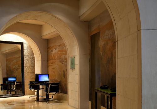 a hallway with an archway with a desk and a computer at The David Citadel Jerusalem in Jerusalem
