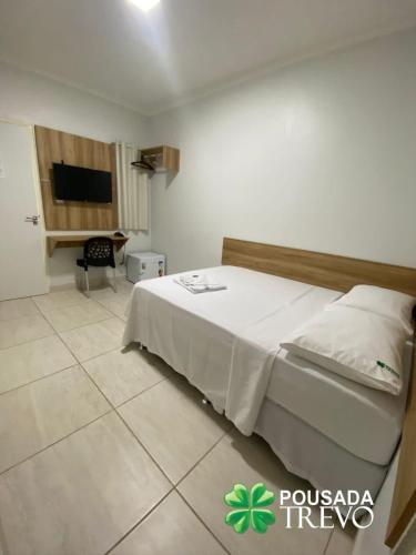 a hotel room with a bed and a desk at Hotel Trevo Caruaru in Caruaru