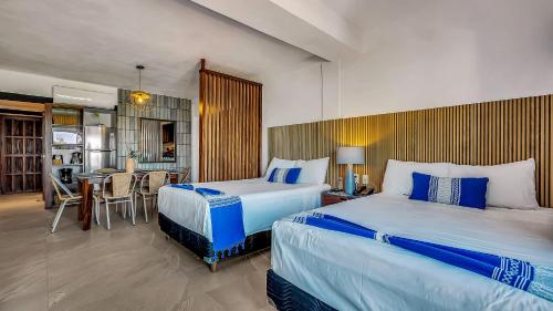 a hotel room with two beds and a kitchen at Marboka Hotel & Suites in Puerto Vallarta
