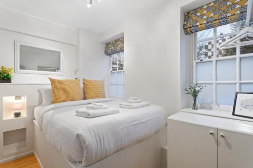 a white bedroom with a bed and a window at Trendy 1 Bedroom Apartment in the Heart of London in London