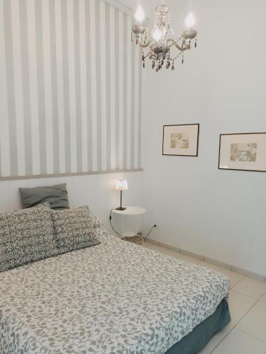 una camera con letto e lampadario a braccio di B&B Dei Decumani a Napoli