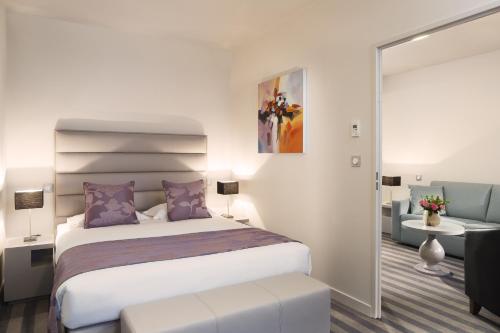 - une chambre avec un lit et des oreillers violets dans l'établissement Executive Hôtel Paris Gennevilliers, à Gennevilliers