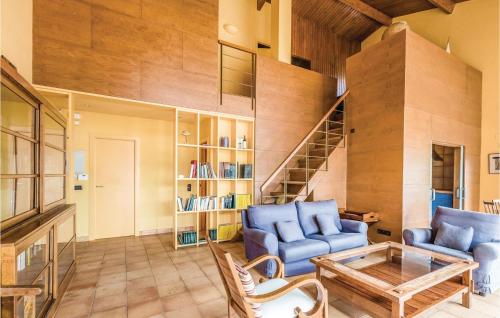 a living room with two blue chairs and a table at Casa Oliver in Capmany