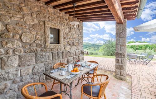 a stone walled patio with a table and chairs at La Selvarella in Seggiano