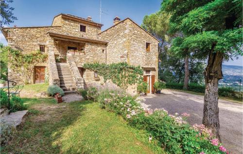 an old stone house with a garden in front of it at Casa Al Vento Near Arezzo in Battifolle
