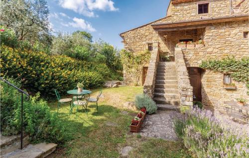 a garden with a table and chairs and a building at Casa Al Vento Near Arezzo in Battifolle