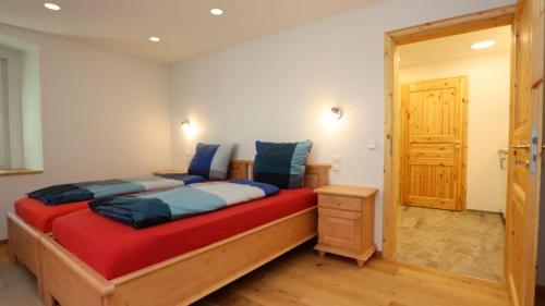 una camera da letto con un grande letto in legno con cuscini blu di Gästezimmer Hof Stallegg a Löffingen