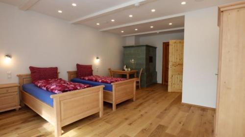 a large room with two beds and a table at Gästezimmer Hof Stallegg in Löffingen