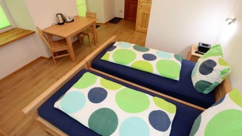 two beds in a room with a table and a desk at Gästezimmer Hof Stallegg in Löffingen