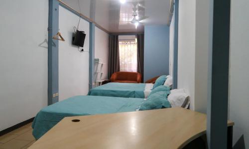 um quarto de hospital com duas camas e uma mesa em Hotel Hoja de Oro Corcovado em Puerto Jiménez