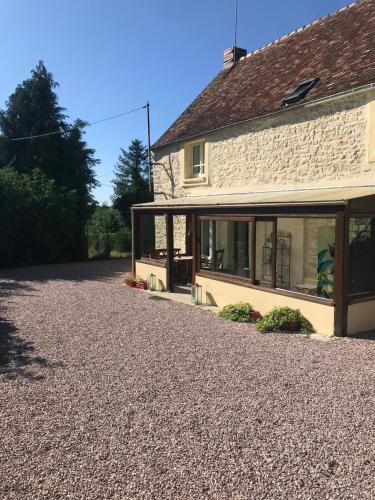 a house with a gravel driveway in front of it at B&B La Vandelière Chambres chez l'Habitant in Macé