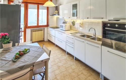 una cocina con armarios blancos y una mesa con fregadero en Casa Adele, en Cattolica