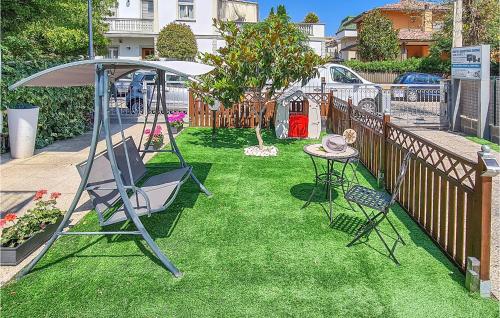 un patio con un columpio, una mesa y una valla en Casa Adele, en Cattolica