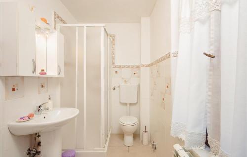 a white bathroom with a toilet and a sink at Casa Di Greta in Santo Stefano di Magra