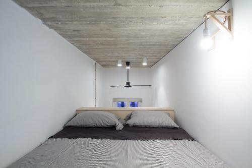 een slaapkamer met een bed in een witte kamer bij QUIRKY in Il-Gżira